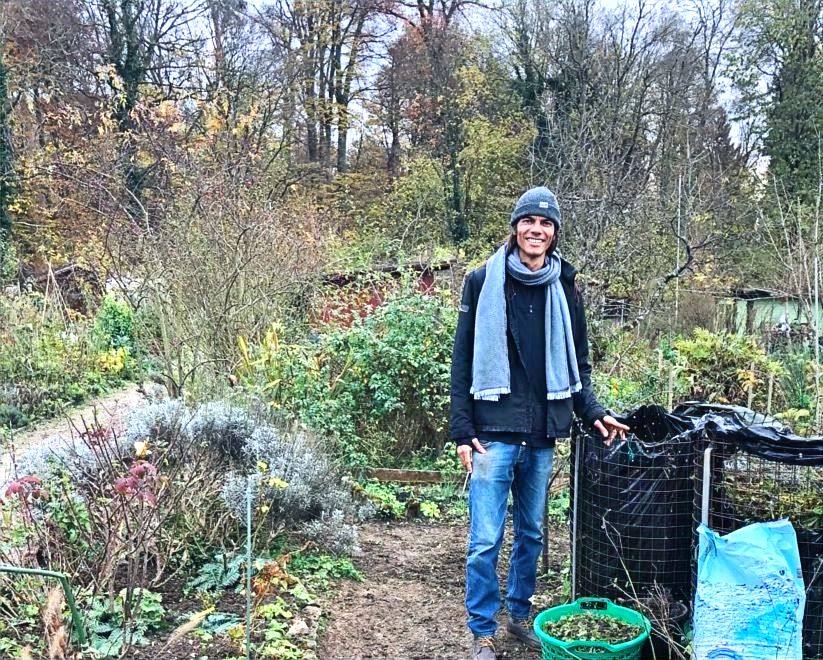 Tido im Garten neben Kompostbehälter und Säcken